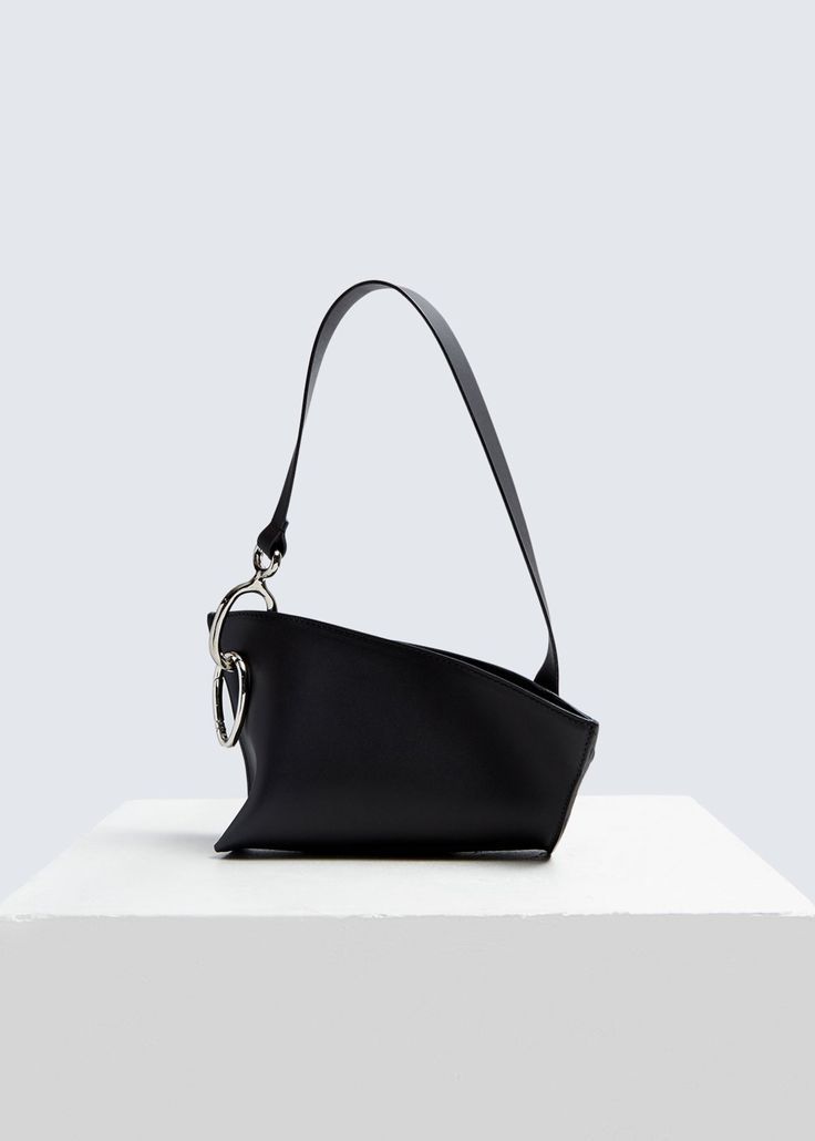 Sac design femme tendance en cuir noir avec une bandoulière élégante et un accessoire chic