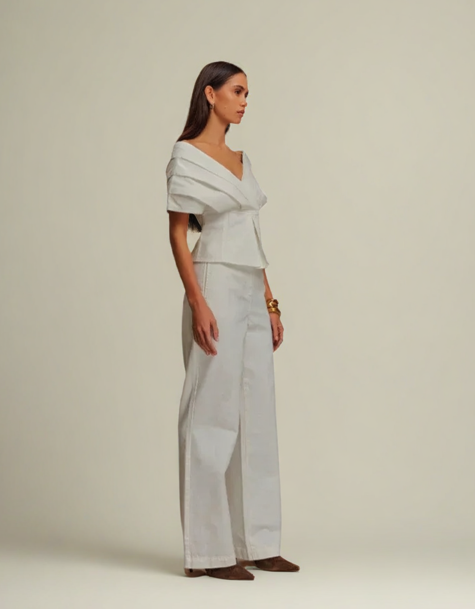 Ensemble denim dos nu en blanc avec un haut drapé et un pantalon large, parfait pour un look élégant
