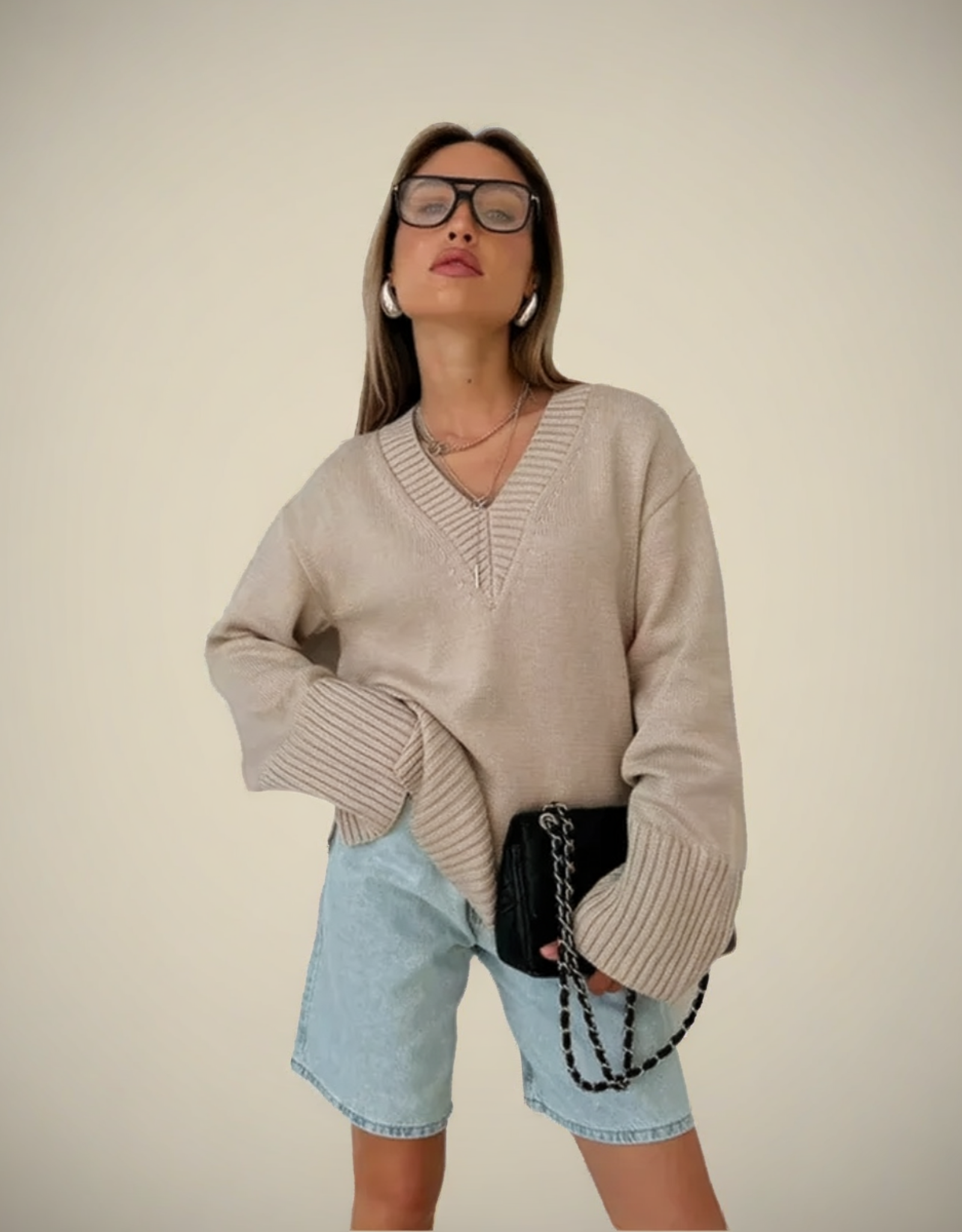 Pull femme col V maille épaisse en beige, idéal pour un style décontracté avec un short en jean
