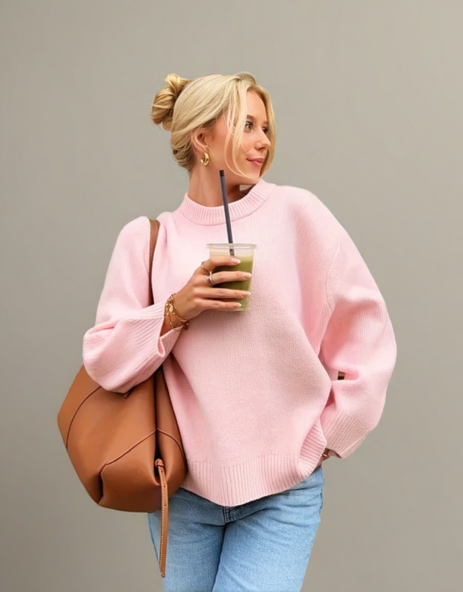Pull rose confortable en laine de Fondelier porté avec un sac tanné et une boisson rafraîchissante
