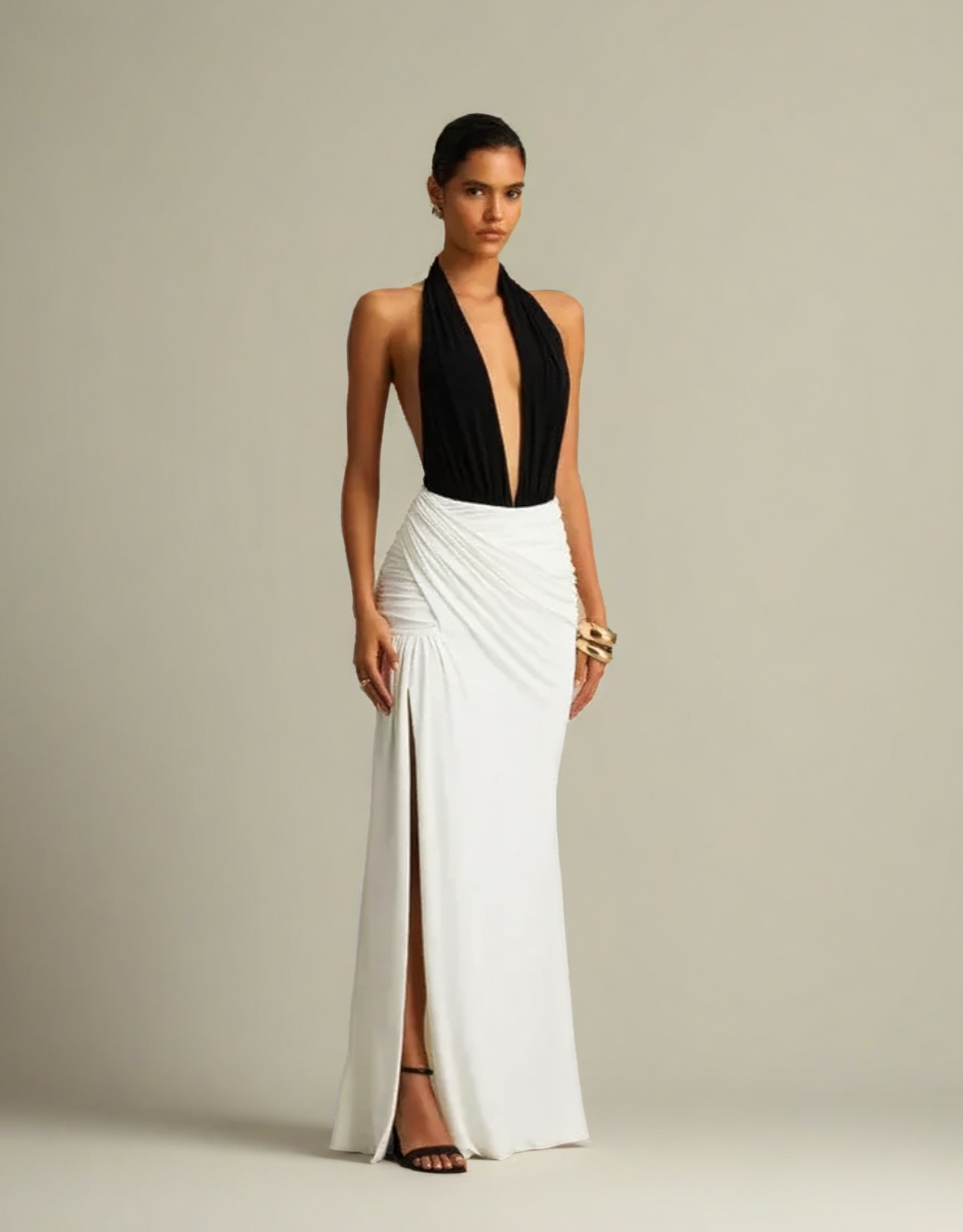 Robe soirée blanche et noire femme avec décolleté plongeant et jupe drapée pour une élégance sophistiquée.