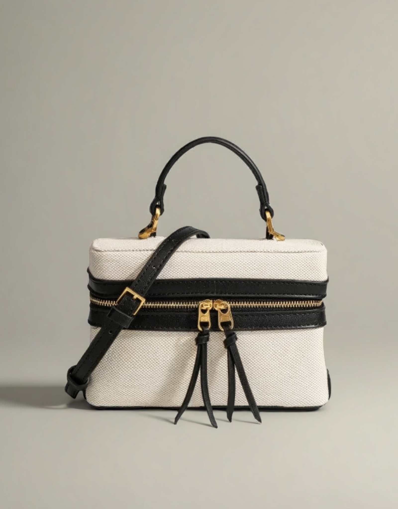 Sac femme rigide toile avec anses noires et fermeture éclair dorée, élégant et modern.