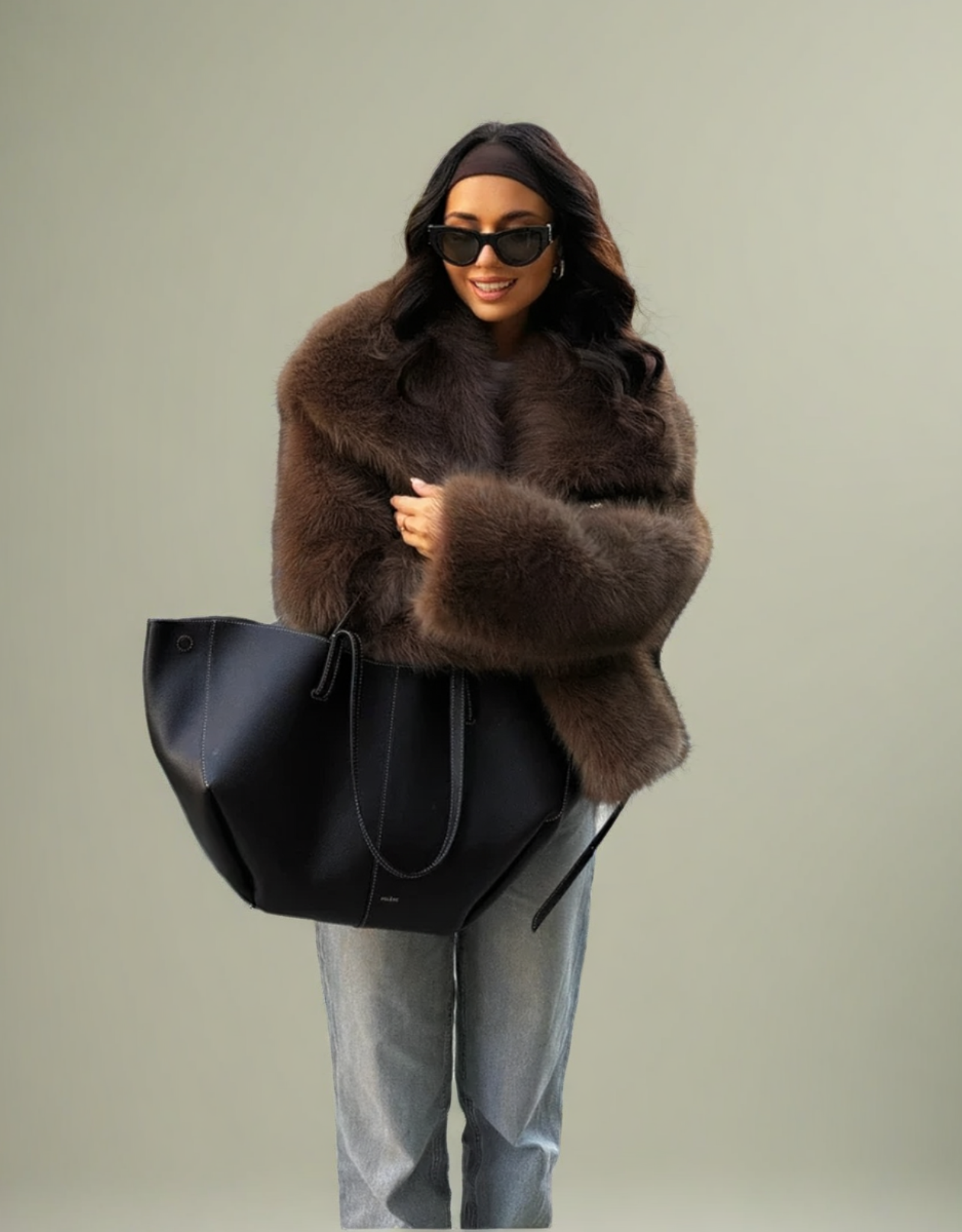 Veste femme fausse fourrure marron portée avec un sac noir et des jeans décontractés